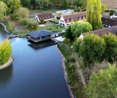 Bord du plan d'eau avec ponton et chalets au camping maeva Respire Domaine de Sainte Montaine