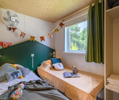 Chambre avec deux lits simples et fenêtre dans le camping maeva Respire de La Croze