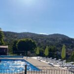 Piscine extérieure avec transats et parasols au camping maeva Respire de La Croze