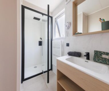 Salle de bain avec douche et lavabo dans le Camping maeva Respire de La Croze