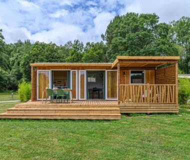 Terrasse en bois et pelouse devant le mobil-home au Camping maeva Respire de La Croze