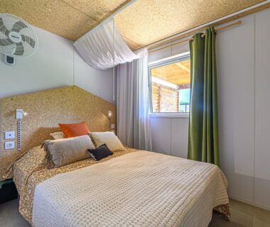 Chambre avec lit double et fenêtre dans le Camping maeva Respire de La Croze