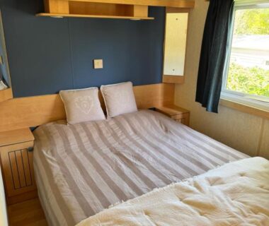 Chambre avec lit double et rangements dans l'hébergement du Camping paradis