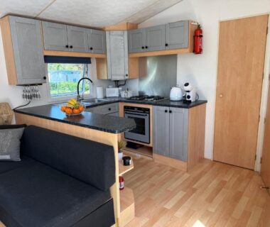 Intérieur de mobil-home avec salon et kitchenette au Camping paradis