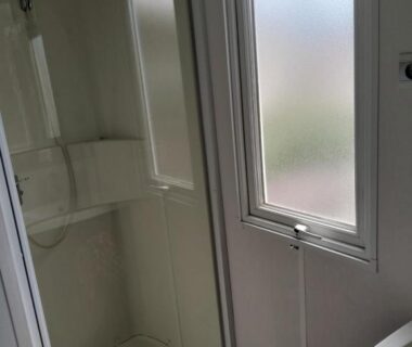 Salle d'eau avec cabine de douche et fenêtre dans le camping Sable du Midi 4 étoiles