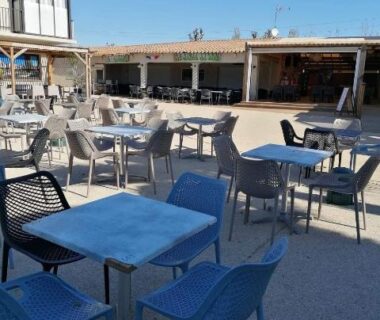 Terrasse extérieure avec tables et chaises au Camping sable du midi 4 etoiles