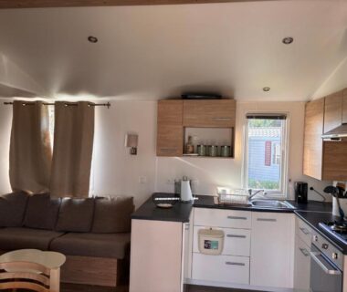 Séjour avec kitchenette et canapé dans l'hébergement du Camping siblu