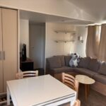 Salon avec canapé et coin repas dans le mobil-home du Camping siblu