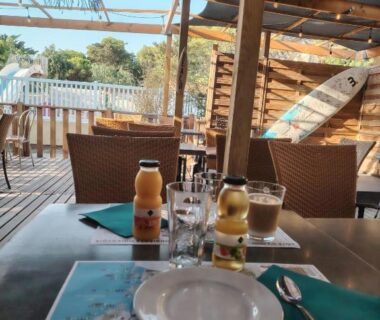 Terrasse ombragée avec table dressée et boissons au camping Cap du Roc