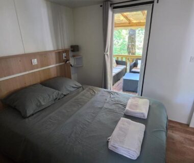 Chambre avec lit double et terrasse donnant sur l'extérieur au Cap'Océan Lodge