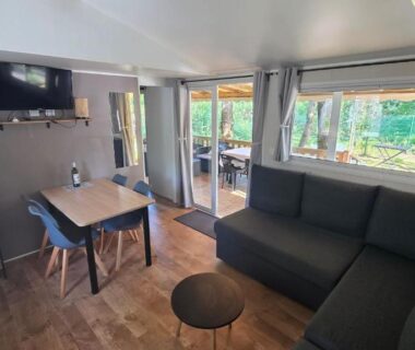 Salon avec canapé et coin repas dans le Cap'Océan Lodge