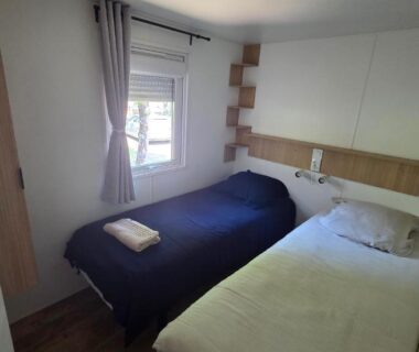 Chambre avec deux lits séparés et fenêtre dans le Cap'Océan Lodge