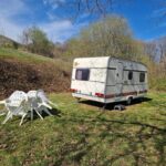 Prairie avec caravane et salon de jardin au Caravan Lara Camping La Foret du Morvan
