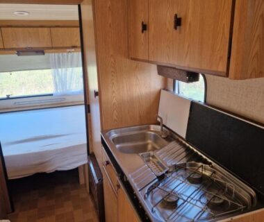 Intérieur de caravane avec kitchenette et lit dans la Caravan Lara Camping La Foret du Morvan