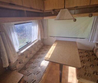Intérieur de caravane avec banquettes et table dans le Caravan Lara Camping La Foret du Morvan