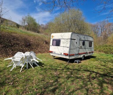 Prairie avec caravane et salon de jardin au Caravan Lara Camping La Foret du Morvan