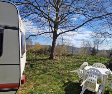 Emplacement herbeux avec caravane et table de jardin du Caravan Lara Camping La Foret du Morvan