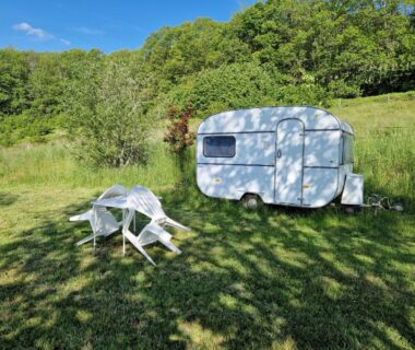 Caravane posée sur pelouse avec table et chaises au Camping Caravan Miekie La Foret du Morvan