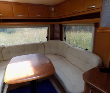 Coin salon avec banquette en U et table dans la Caravan du Loch