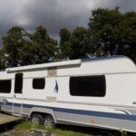 Parcelle herbeuse avec caravane blanche stationnée au Caravan du Loch
