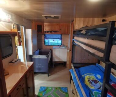 Intérieur de la caravane avec lits superposés télévision et kitchenette dans la Caravane 4 personnes au camping d'Aussois