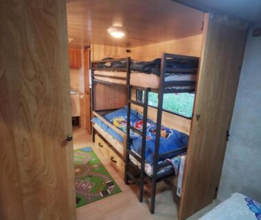 Intérieur de caravane avec lits superposés et coin cuisine dans la Caravane 4 personnes au camping d'Aussois