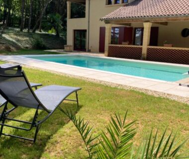 Piscine extérieure et transats dans le jardin de la Caravane La Clairière