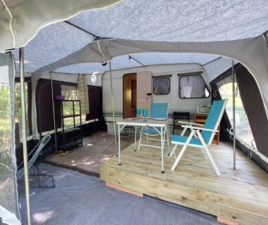 Auvent de caravane avec terrasse en bois et mobilier de plein air dans la Caravane La Clairière