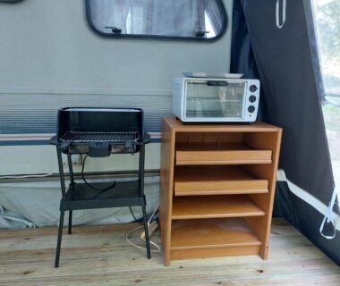 Intérieur de caravane avec barbecue, four et étagère dans la Caravane La Clairière