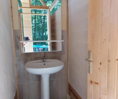 Cabine avec lavabo et miroir dans la Caravane La Clairière