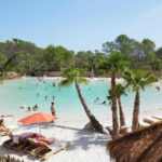 Lagune aménagée avec plage de sable et palmiers au Carazur Mobilhomes Camping Fréjus