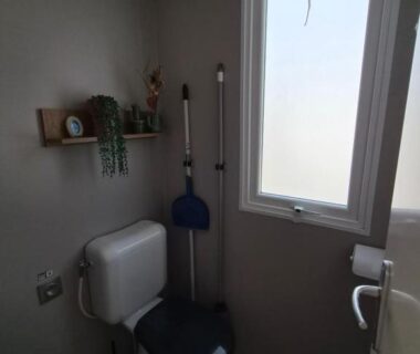 Toilettes compactes avec fenêtre étagère et accessoires dans le mobil home Casa Luisa Mobil Home