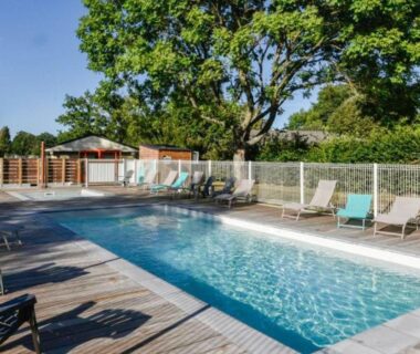Piscine extérieure et chaises longues sur terrasse en bois au Chalet 3 Chambres avec Terrasse pour 6 Personnes