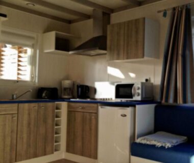 Intérieur coin cuisine avec micro-ondes réfrigérateur et banquette dans le Chalet 3 Chambres avec Terrasse pour 6 Personnes API-1-52-1375