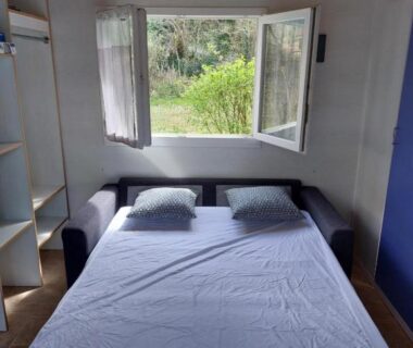Chambre avec lit double et fenêtre ouverte dans le Chalet 6 places