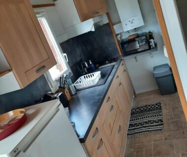 Cuisine aménagée avec réfrigérateur évier rangements et chaudière dans le Chalet 6 places