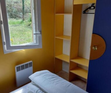 Chambre avec lit et fenêtre donnant sur la verdure dans le Chalet 6 places