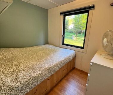Chambre avec lit et fenêtre donnant sur jardin du Chalet 9 personnes piscine terrasse