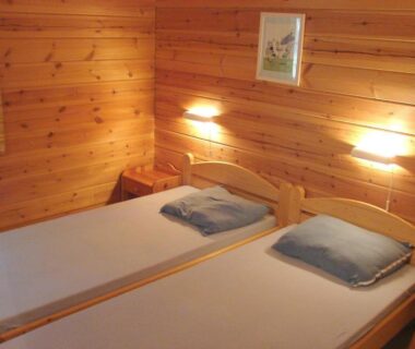 Chambre en bois avec deux lits dans le Chalet Cahors 4 pers.