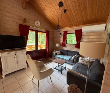 Salon en bois avec canapés et télévision du Chalet Cahors – 4 pers.