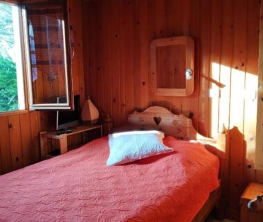 Chambre avec lit et fenêtre dans le Chalet Camping Les Vignes