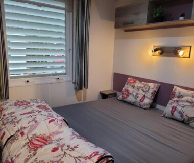 Chambre avec lit double fenêtre et applique murale dans le Chalet Coco