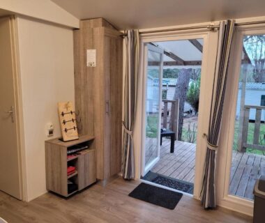 Séjour avec baie vitrée et terrasse en bois du Chalet Coco