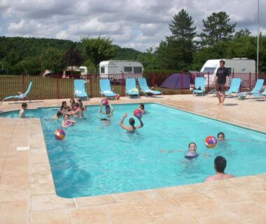 Piscine extérieure avec enfants jouant et transats au Chalet Marin et son spa privatif