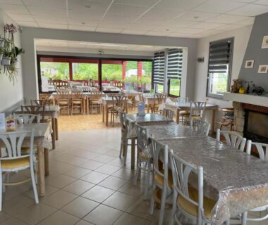 Salle à manger avec tables et cheminée dans le Chalet Marin et son spa privatif