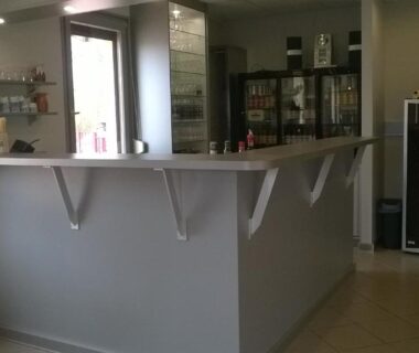 Réception intérieure avec comptoir étagères et réfrigérateur au Chalet Marin et son spa privatif