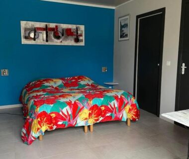 Chambre avec lit fleuri et mur bleu au Chalet Marin et son spa privatif