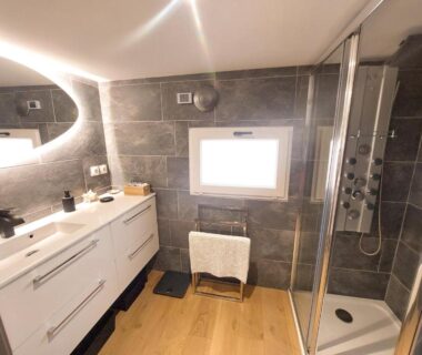 Salle de bain avec douche cabine et double vasque dans le Chalet Oasis et vue mer