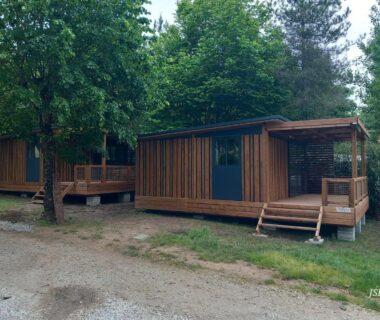 Terrasse en bois et façade de chalet sous les arbres du Chalet Zen