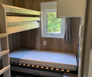 Chambre avec lits superposés et fenêtre sur la pinède dans le Chalet au calme dans la pinède